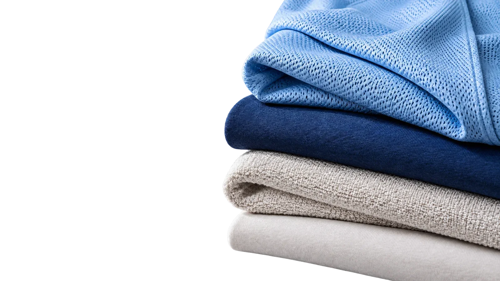 Stack of folded fabrics: sky-blue mesh, navy knit, stone fleece and white terry