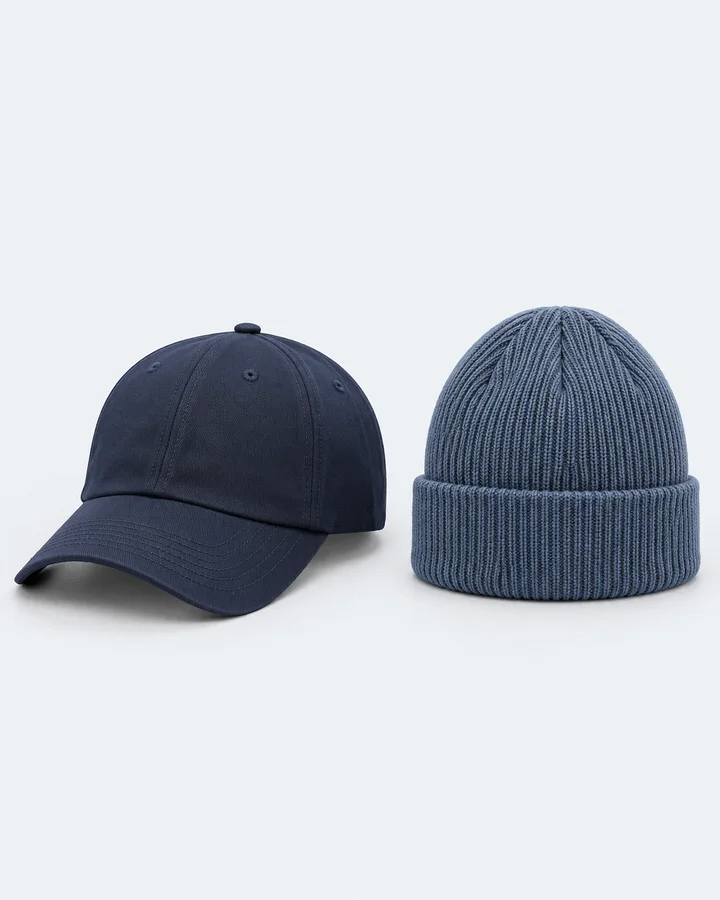Navy six-panel cap beside a steel-blue ribbed beanie