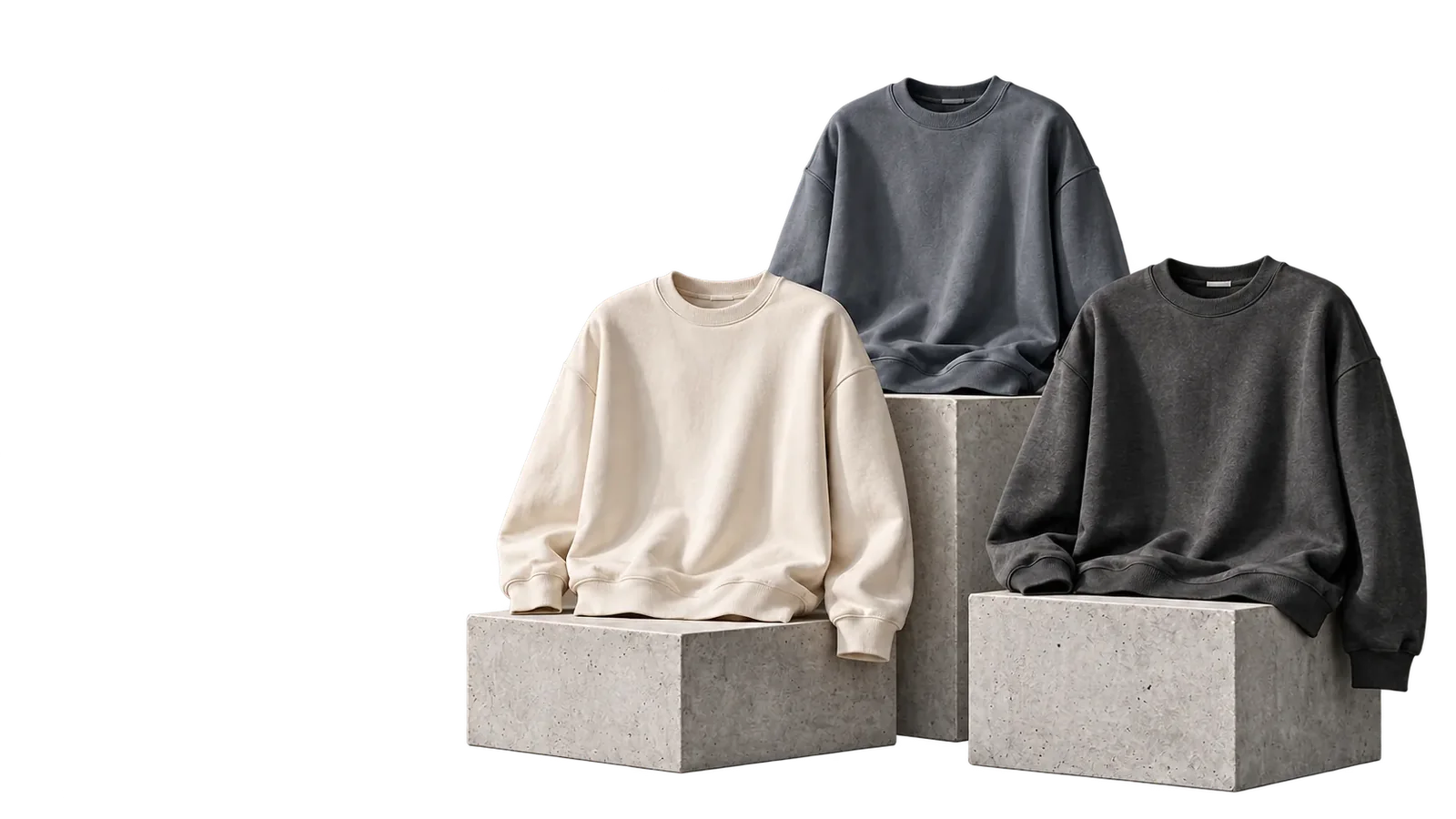 Three crewneck sweatshirts in cream, washed slate and washed black on concrete plinths